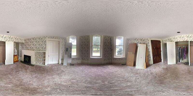 360° view of a bedroom — fireplace flanked by built-in cupboards, patterned wallpaper